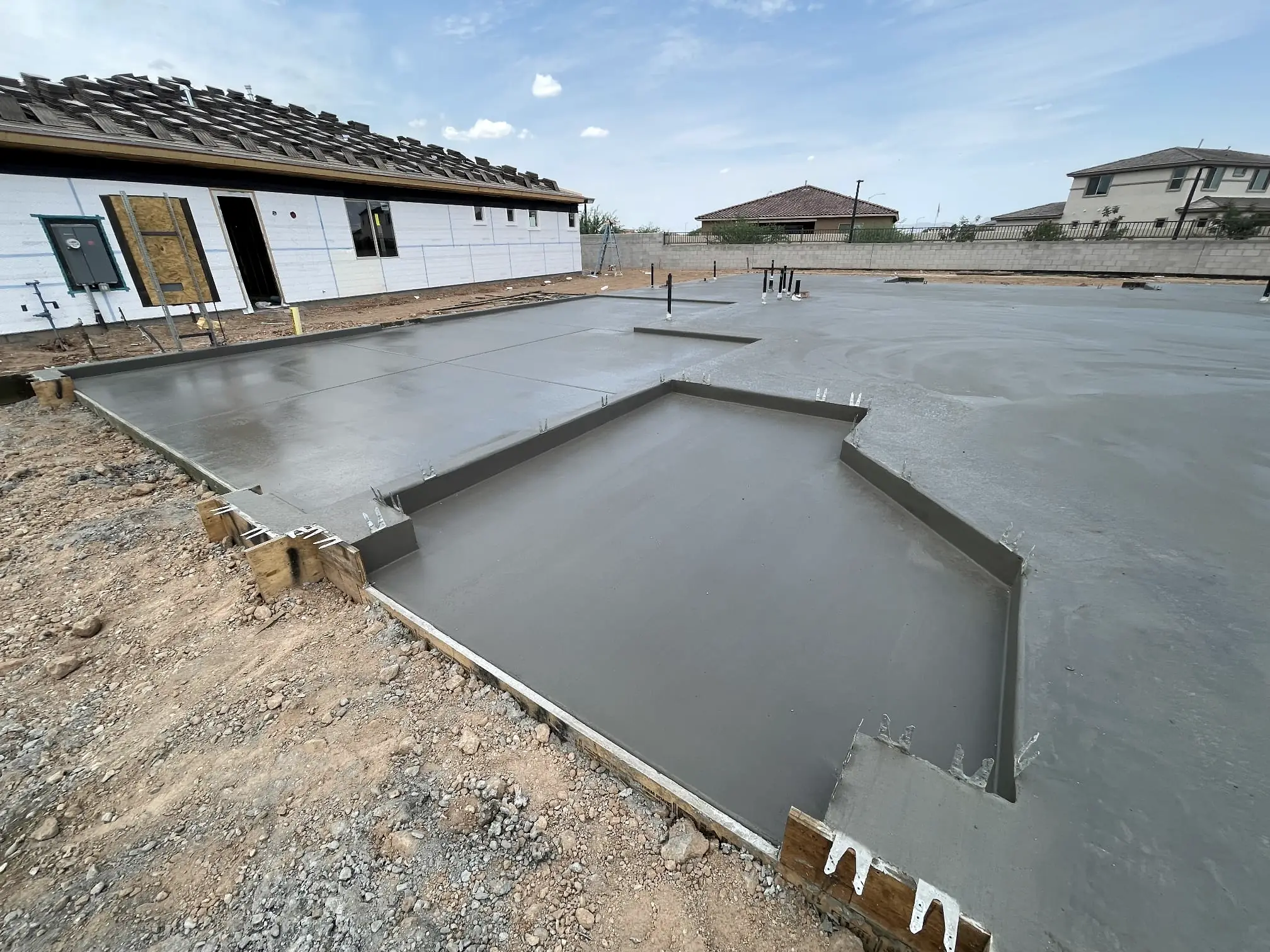 A notched foundation slab next to a new house