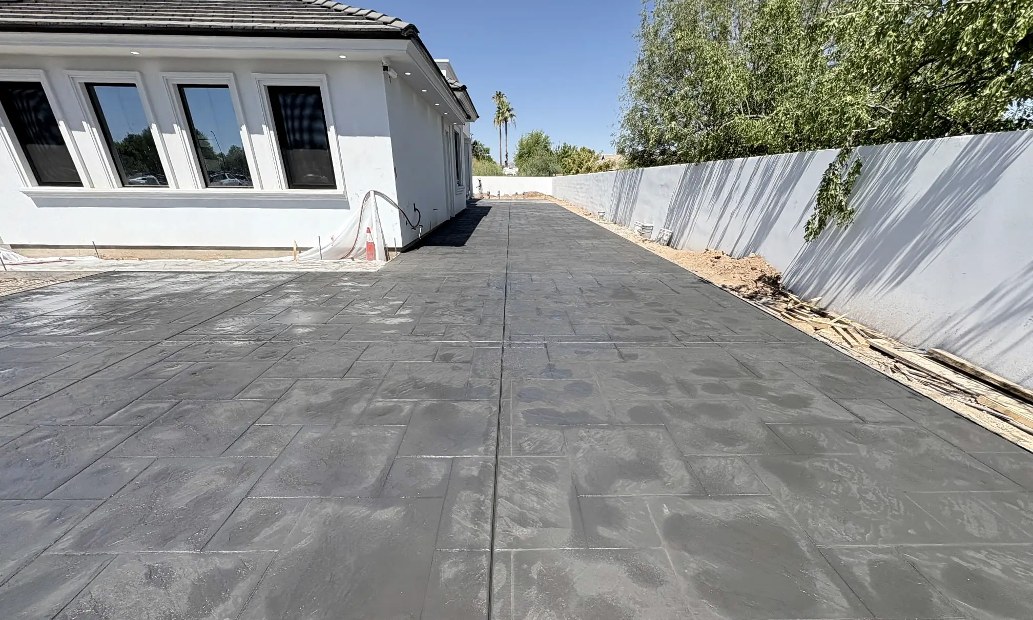 A long scored concrete slab running beside a house